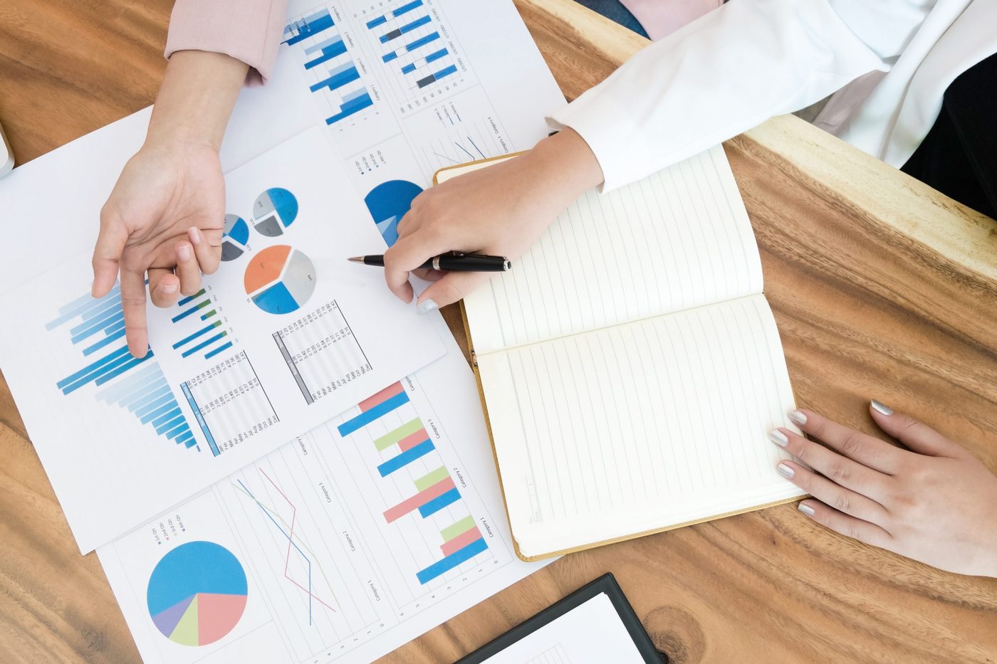 Twee personen bespreken grafieken en diagrammen op papier